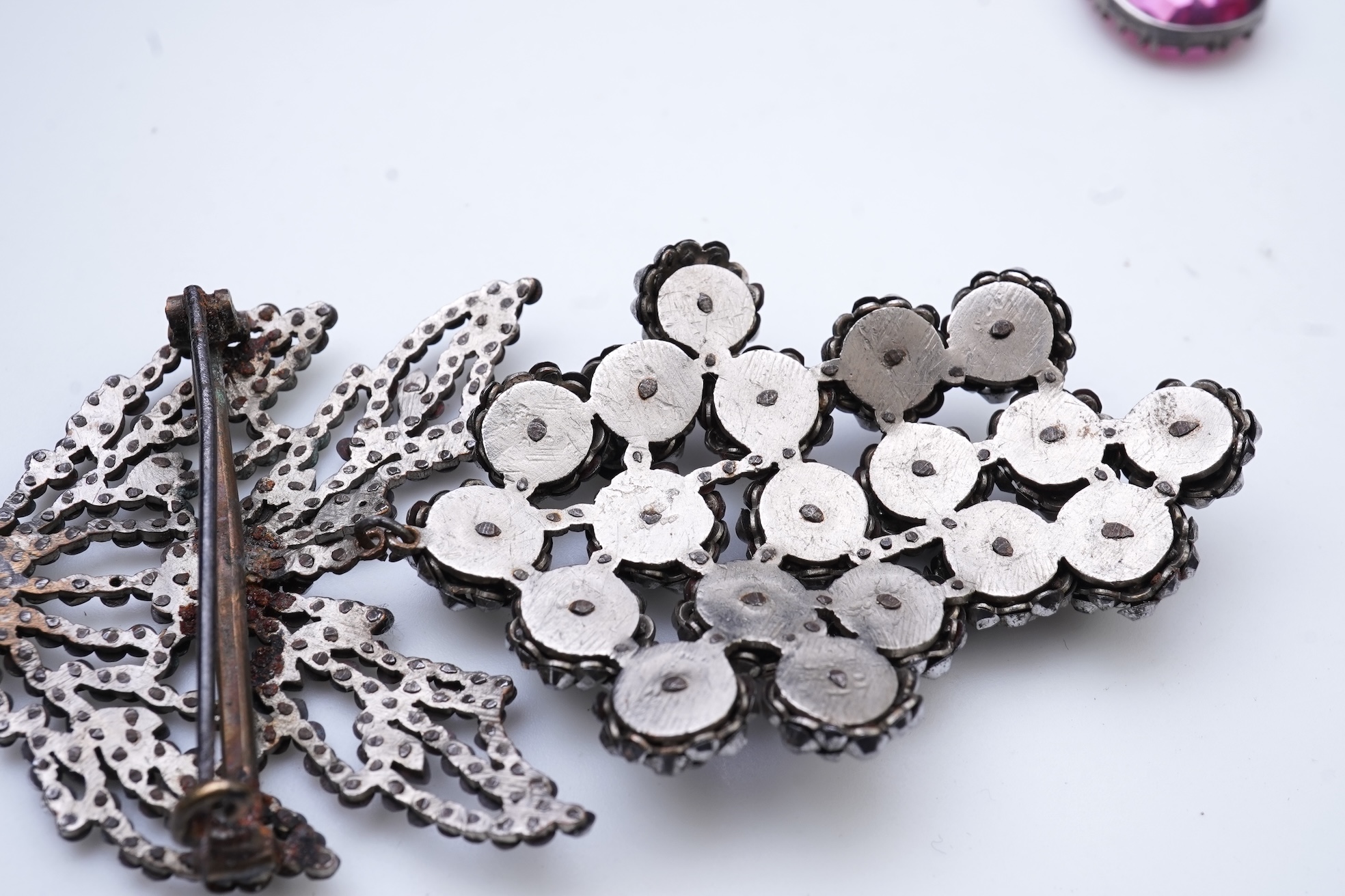 A cut steel brooch, 19th century, and a pink paste pendant
